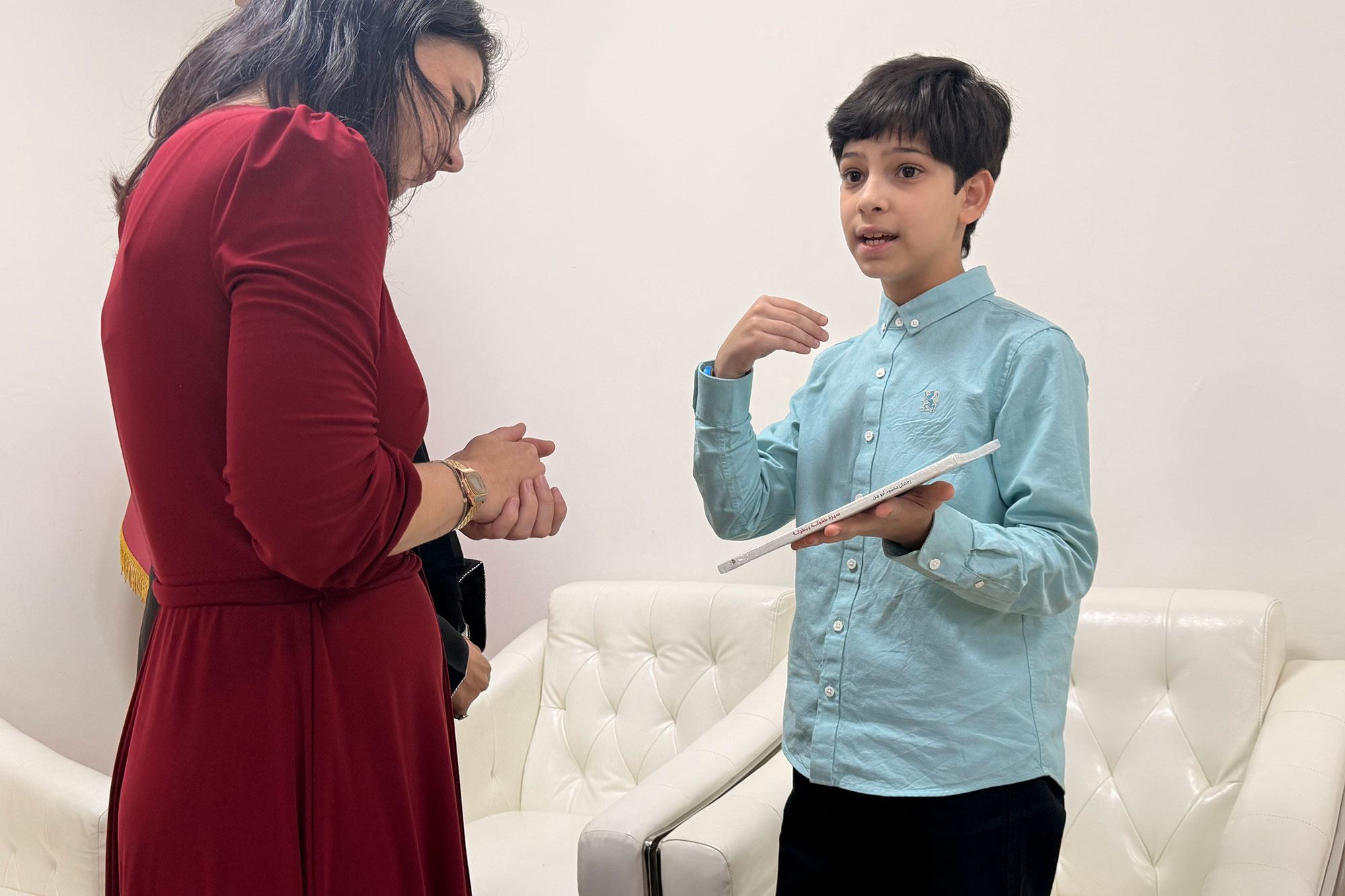 Assembly President Baerbock (left) speaks with a young boy, Ramadan.